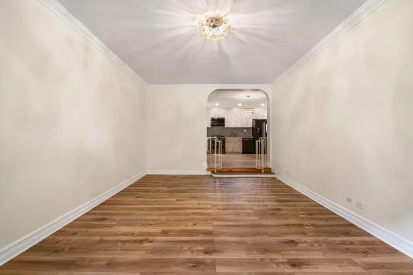 a view of empty room with wooden floor and ceiling fan