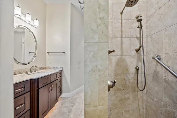 a bathroom with a double vanity sink mirror and shower