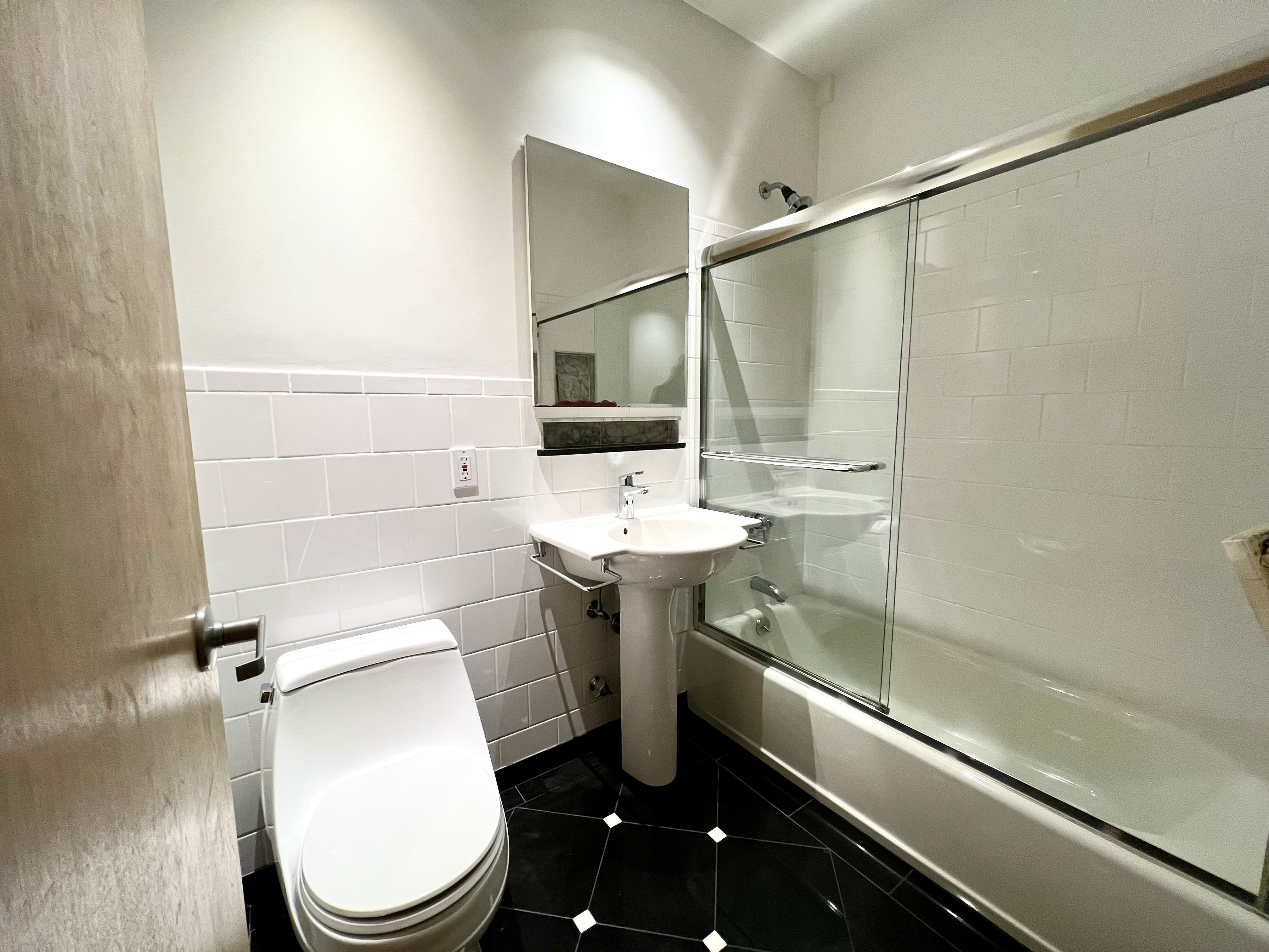 528 West 46th Street, Unit 3E Manhattan, NY 10036 - Photo 5 of 7 a bathroom with a sink mirror toilet and shower