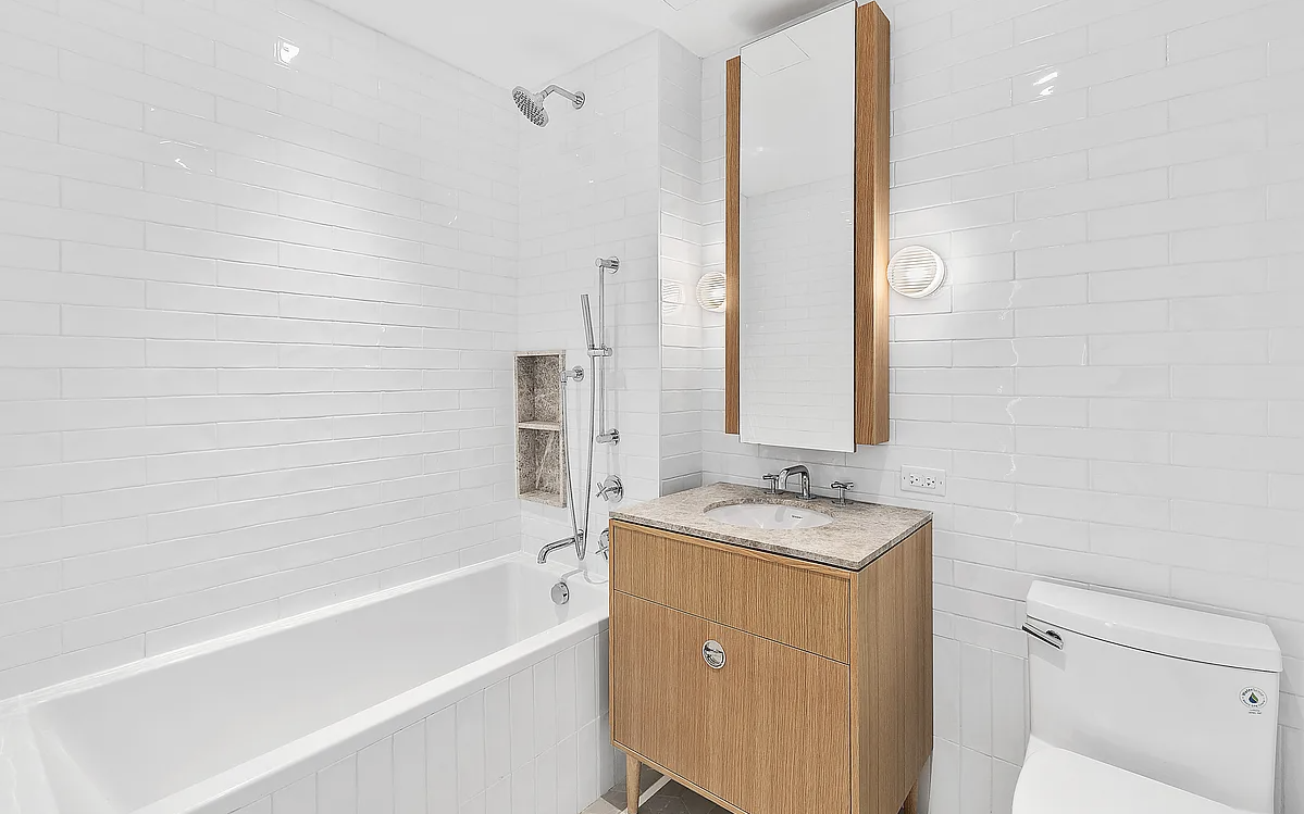 181 18th Street, Unit 408 Brooklyn, NY 11215 - Photo 6 of 13 a bathroom with a granite countertop sink a mirror and a bathtub