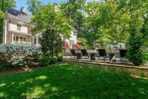 a view of a house with backyard and sitting area