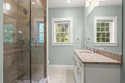 a bathroom with a granite countertop sink and shower