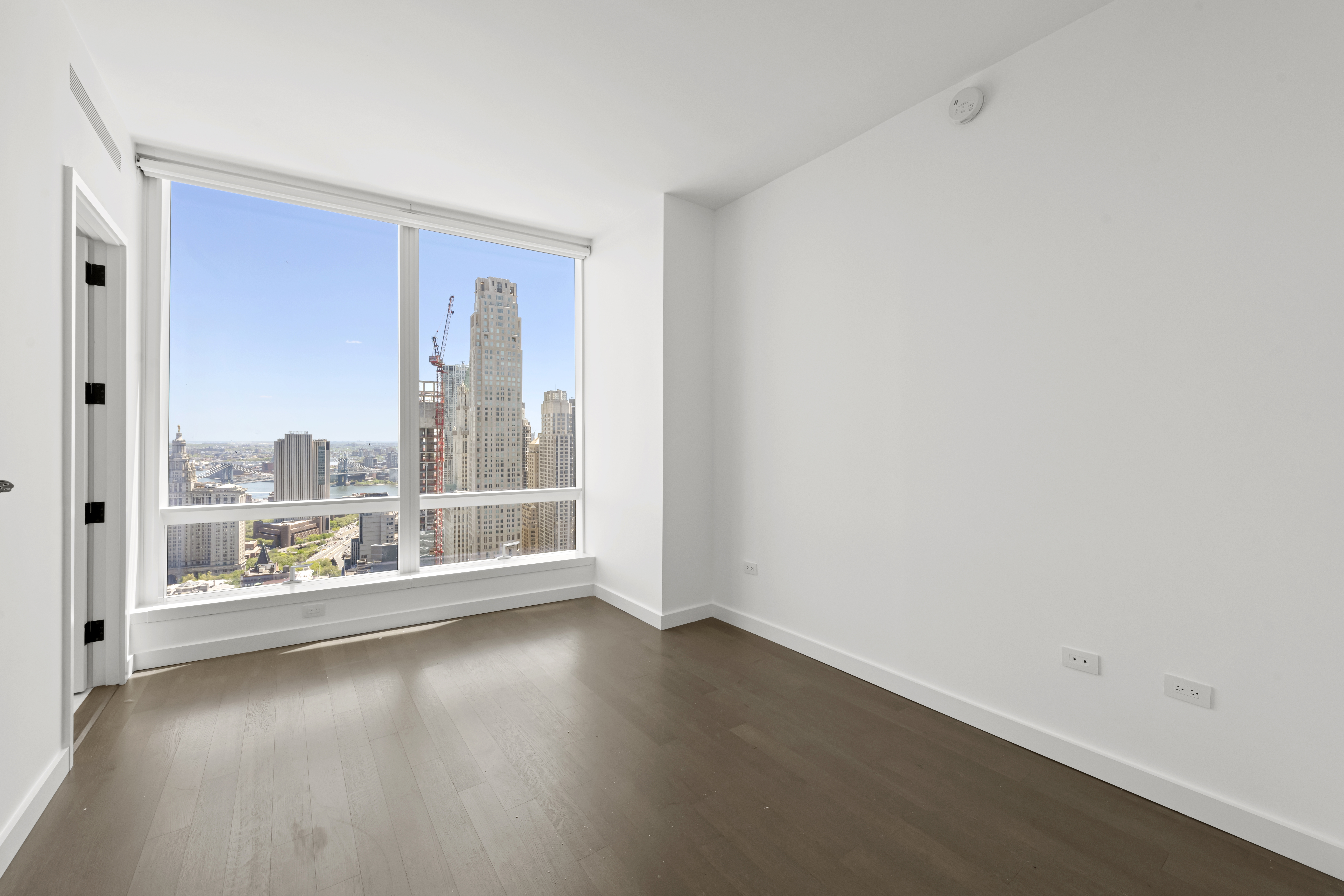 111 Murray Street, Unit 51EAST Manhattan, NY 10007 - Photo 20 of 42 an empty room with wooden floor and windows