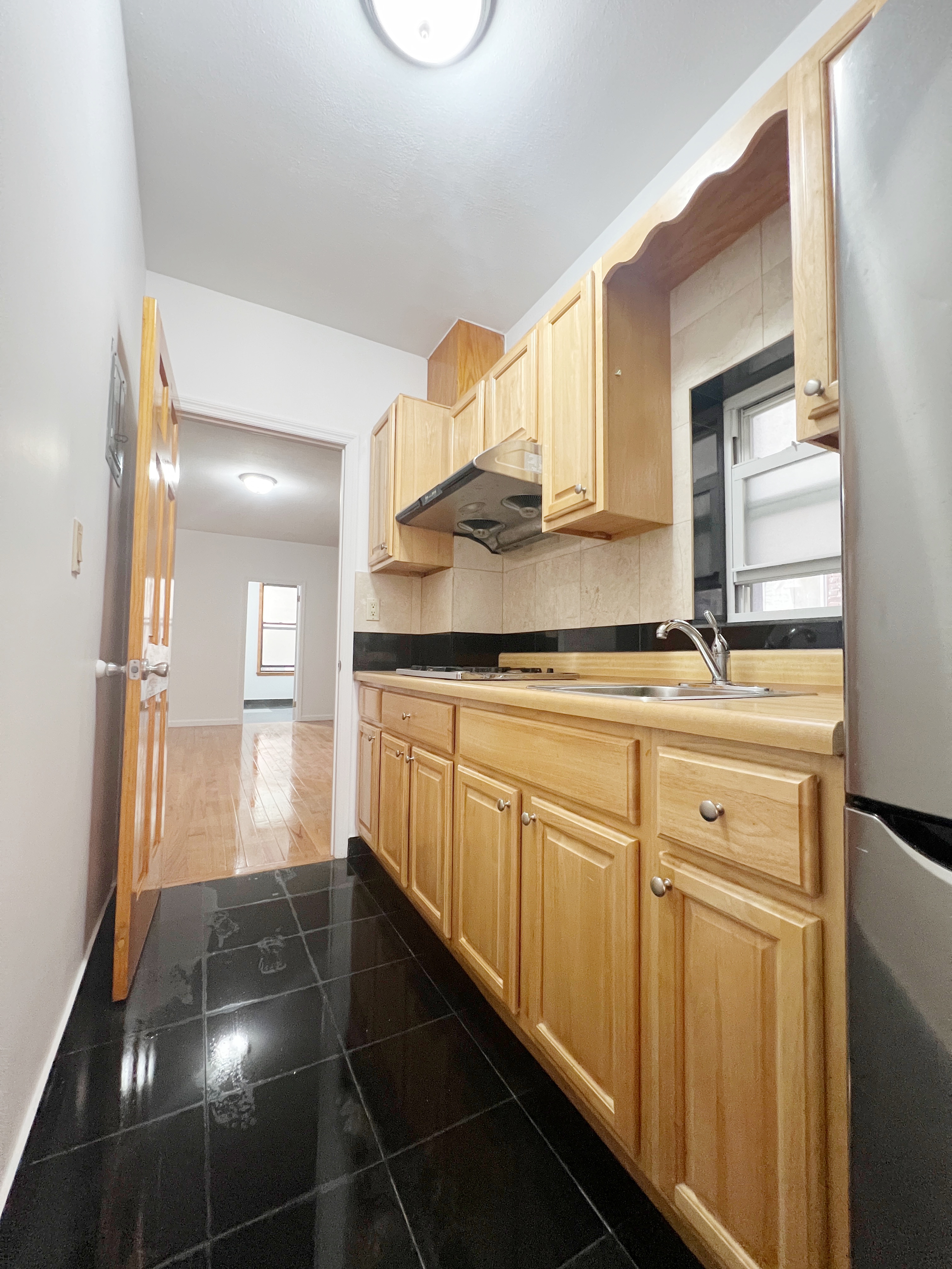 75 Madison Street, Unit 6 Manhattan, NY 10002 - Photo 4 of 5 a kitchen with granite countertop a sink and cabinets