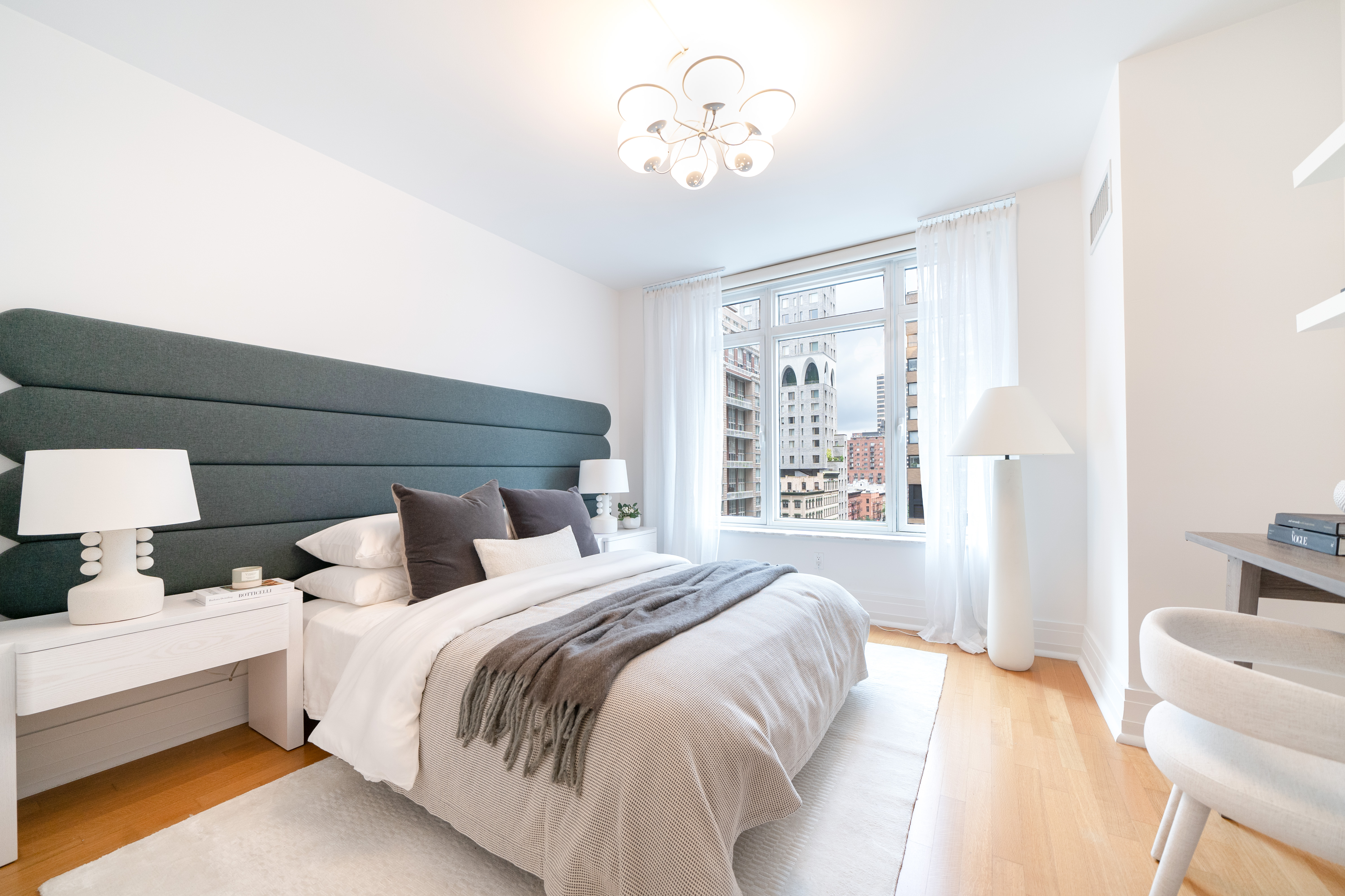 205 East 85th Street, Unit G10 Manhattan, NY 10028 - Photo 16 of 27 a bedroom with a large bed and a chandelier