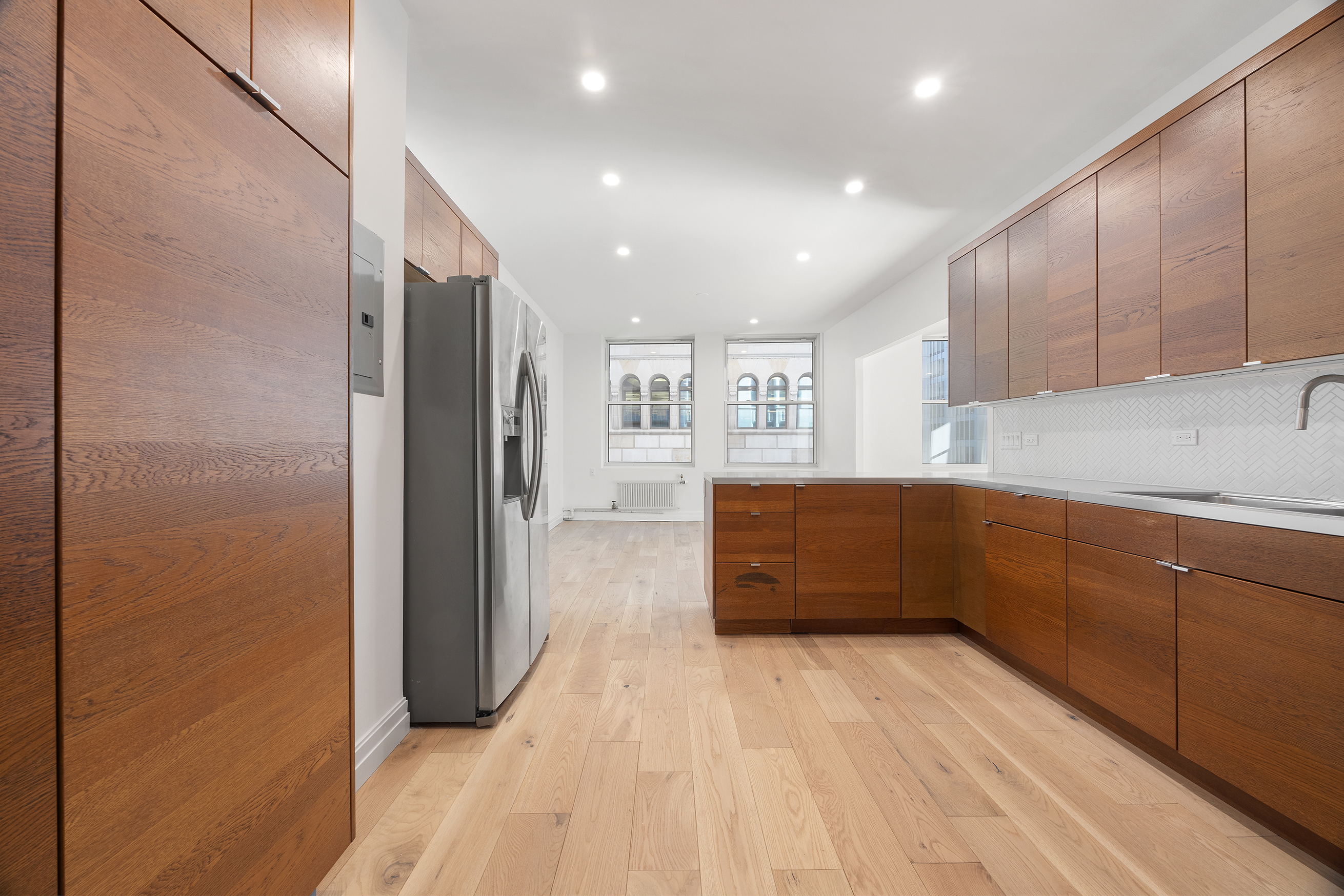 55 Liberty Street, Unit 13C Manhattan, NY 10005 - Photo 5 of 9 a kitchen with stainless steel appliances a refrigerator and a sink