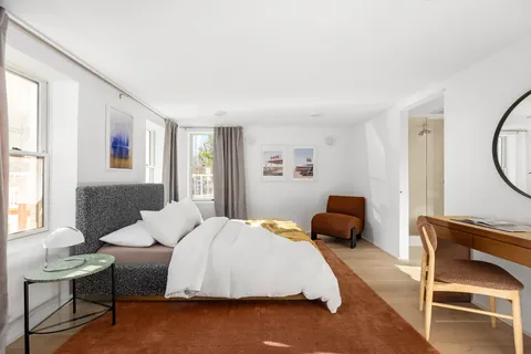 a bedroom with furniture and a window