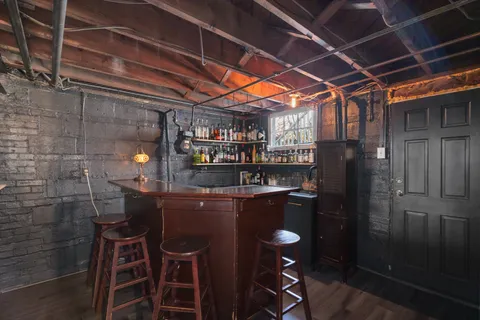 a room with stainless steel appliances kitchen island granite countertop furniture and a refrigerator