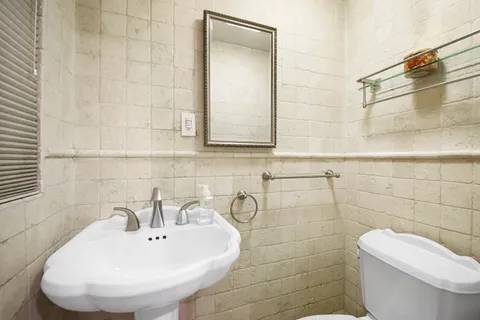a bathroom with a toilet sink and mirror