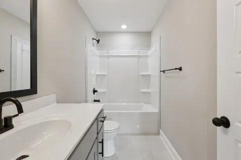 a bathroom with a granite countertop sink a toilet and shower