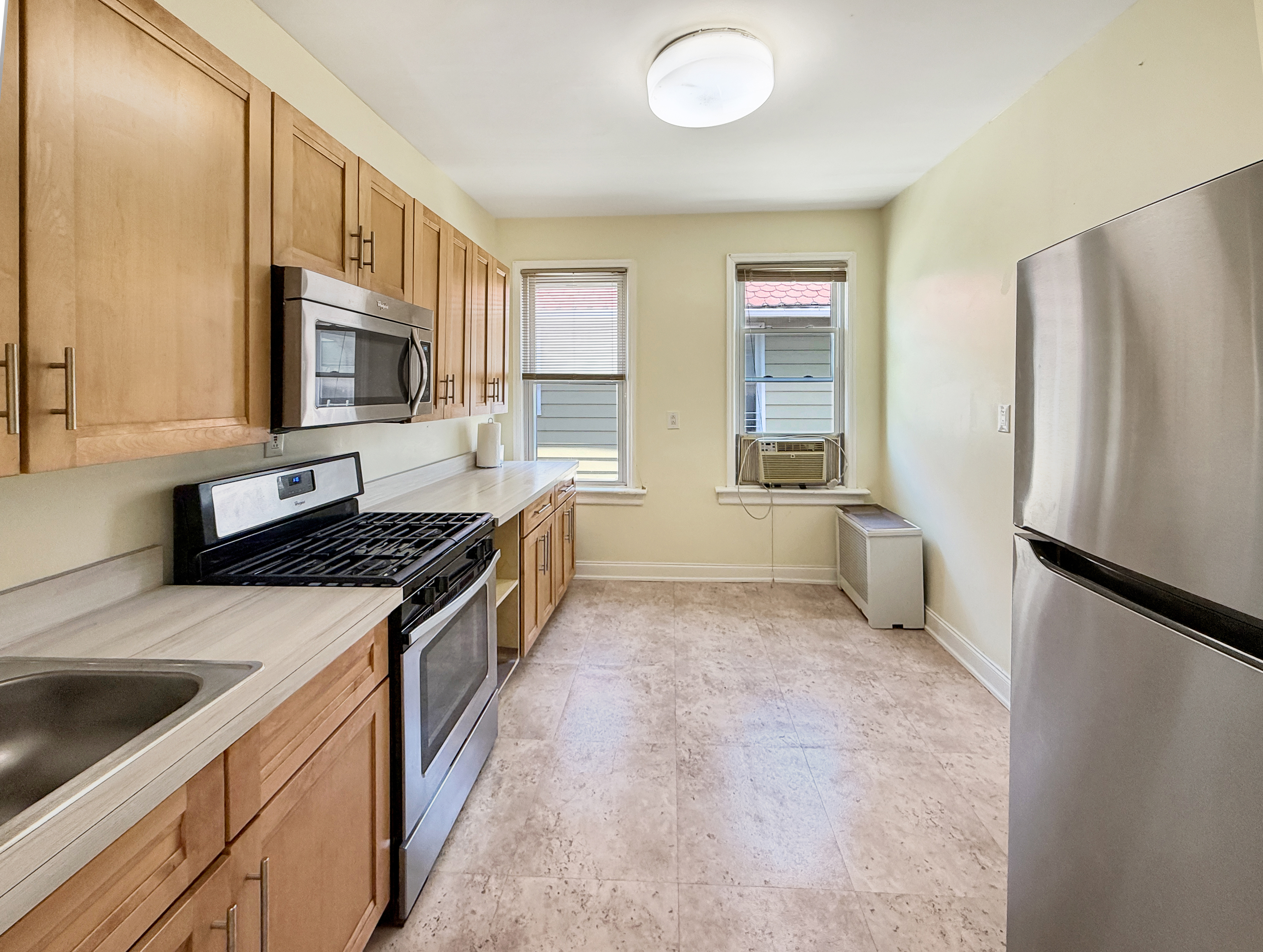 3735 Oceanic Avenue Brooklyn, NY 11224 - Photo 17 of 26 a kitchen with stainless steel appliances granite countertop a refrigerator a stove a sink and a microwave