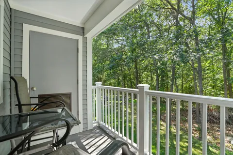 a view of a balcony with chair and wooden floor