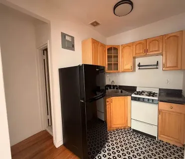 a kitchen with granite countertop a refrigerator and a stove top oven