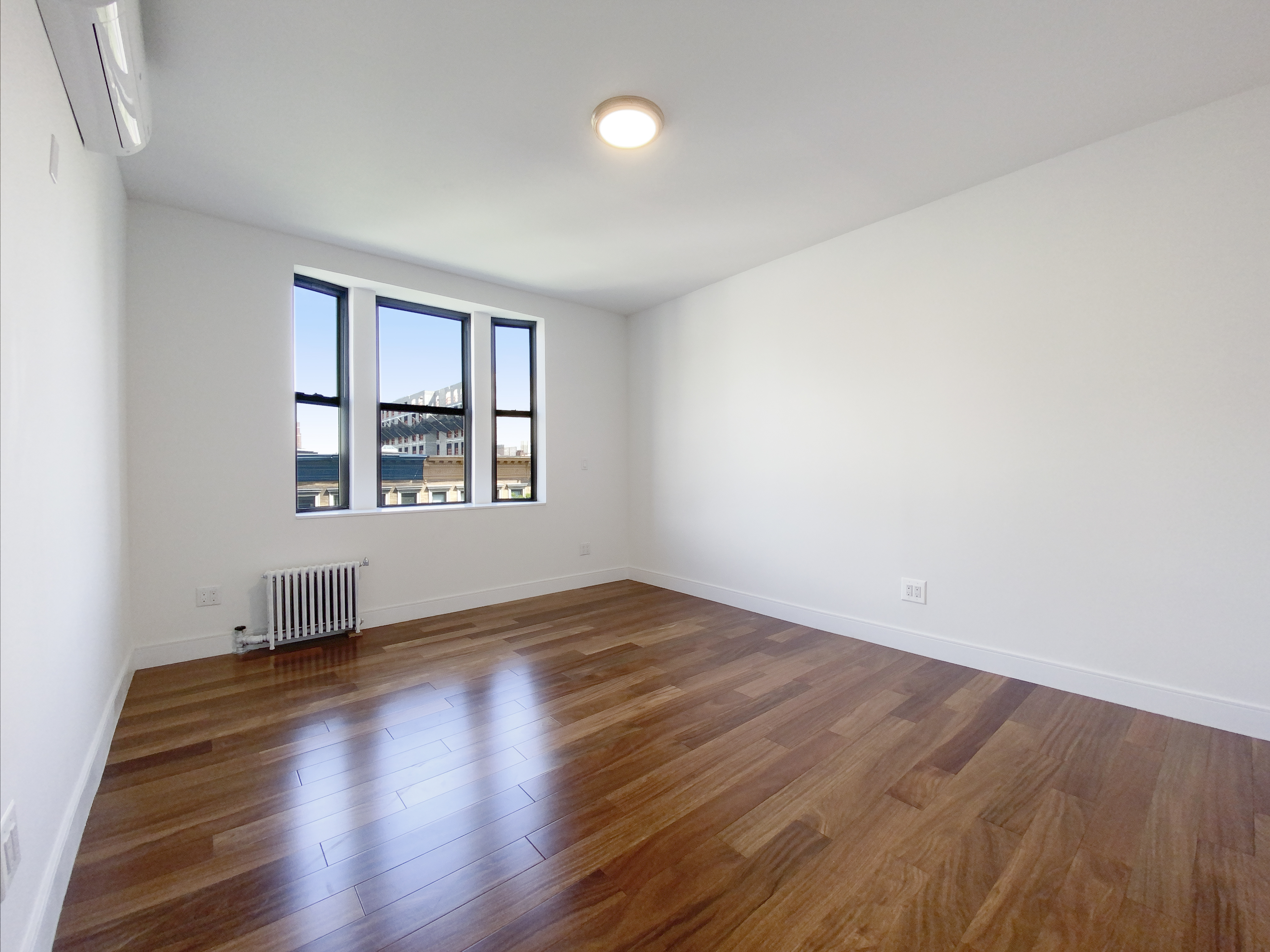 200 West 109th Street, Unit E4 Manhattan, NY 10025 - Photo 5 of 13 an empty room with wooden floor and windows