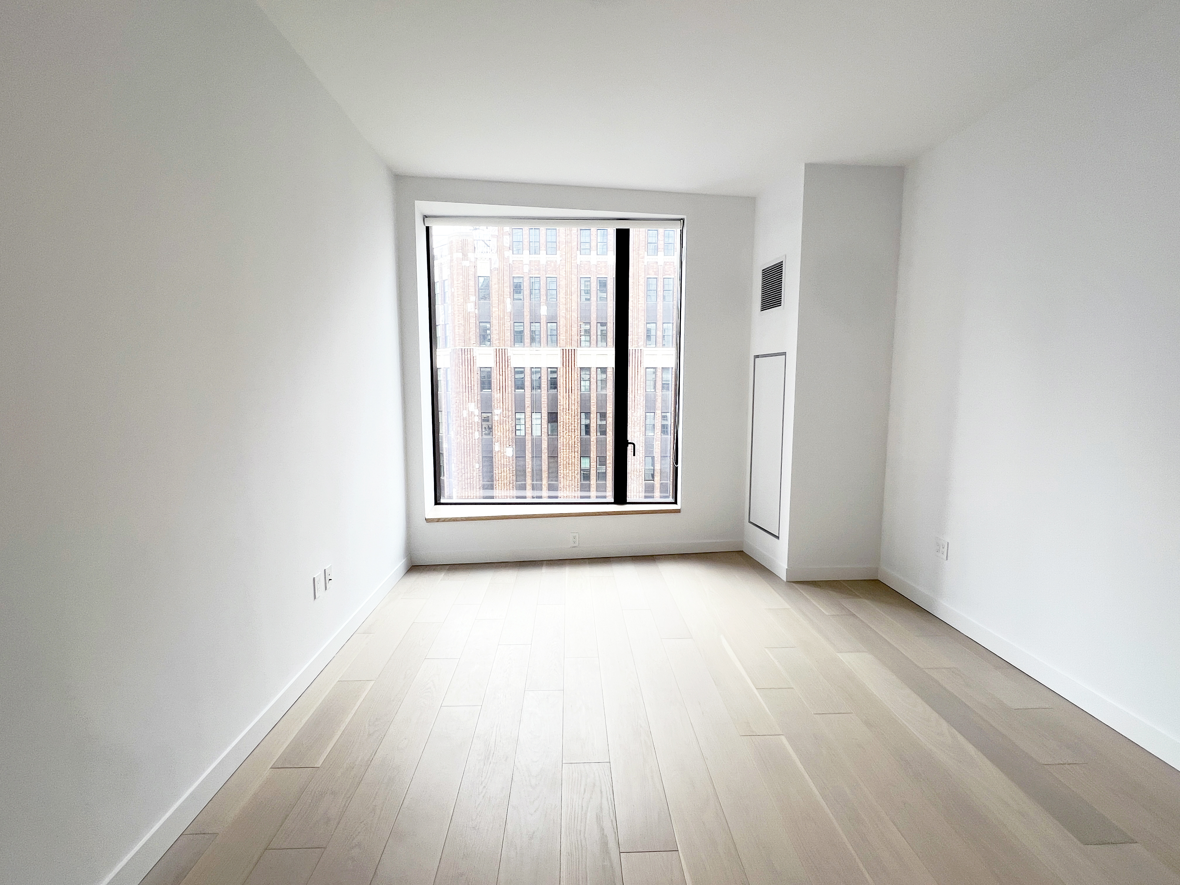 11 Hoyt Street, Unit 10M Brooklyn, NY 11201 - Photo 3 of 24 an empty room with wooden floor and windows