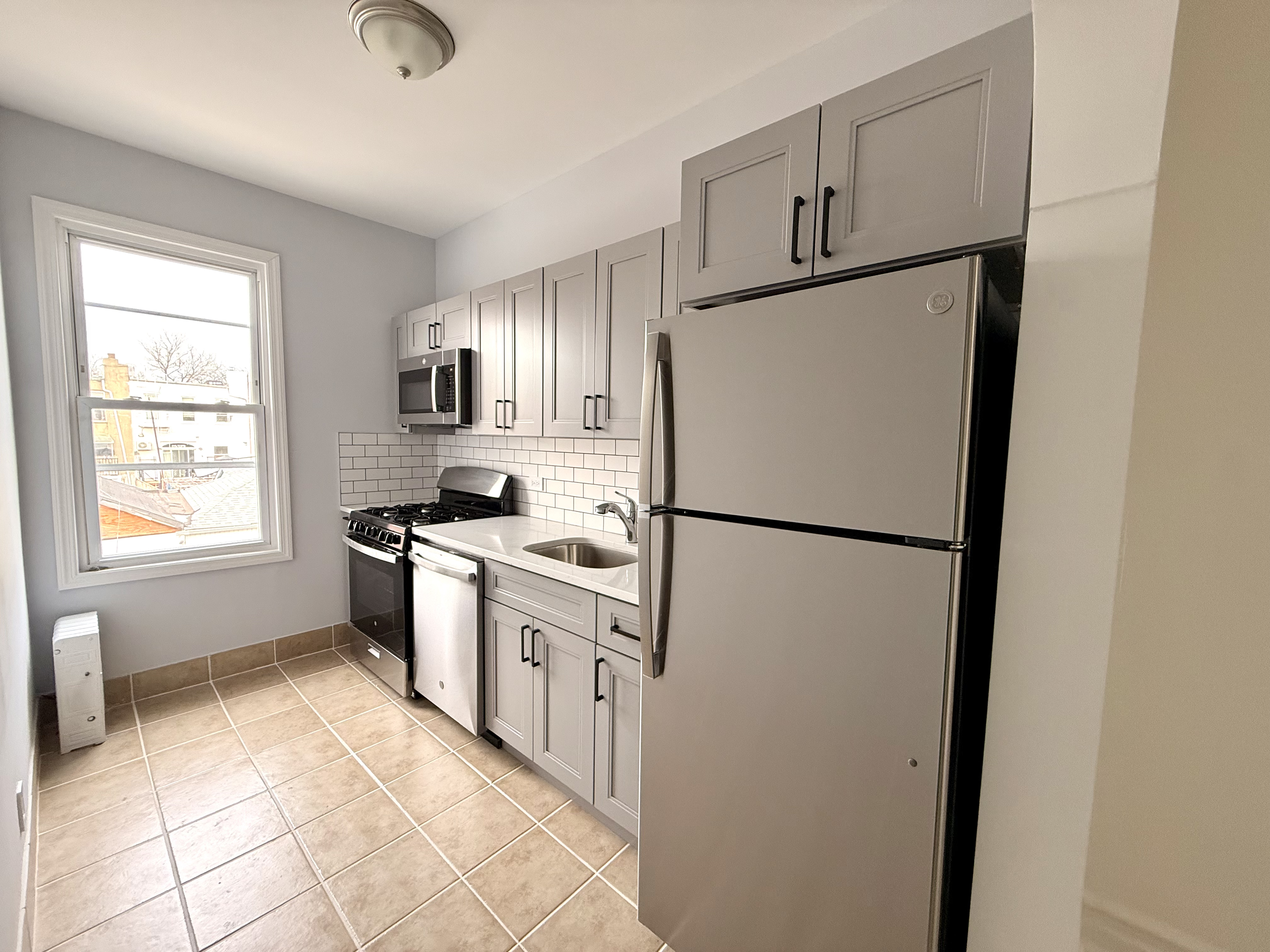 a kitchen with a refrigerator sink stove and cabinets