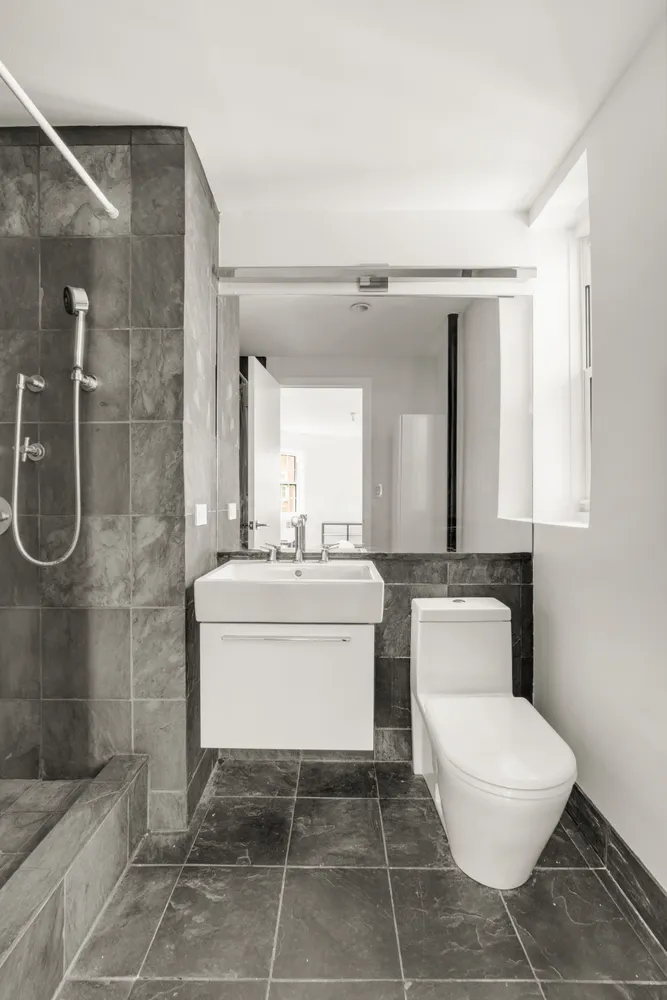 a bathroom with a toilet sink and mirror