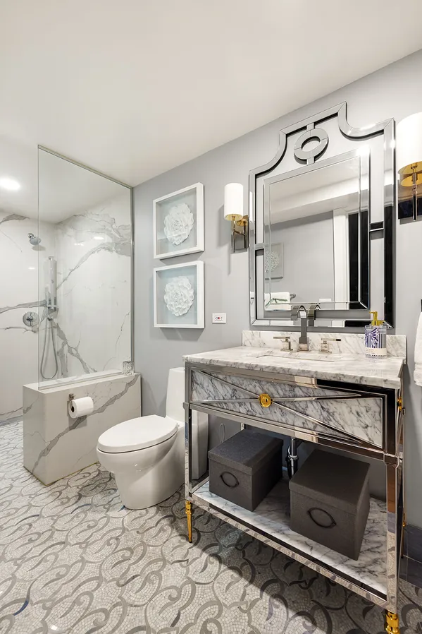 a bathroom with a granite countertop toilet sink and mirror