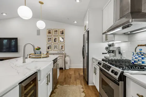 a large kitchen with stainless steel appliances a large center island attached withe living room