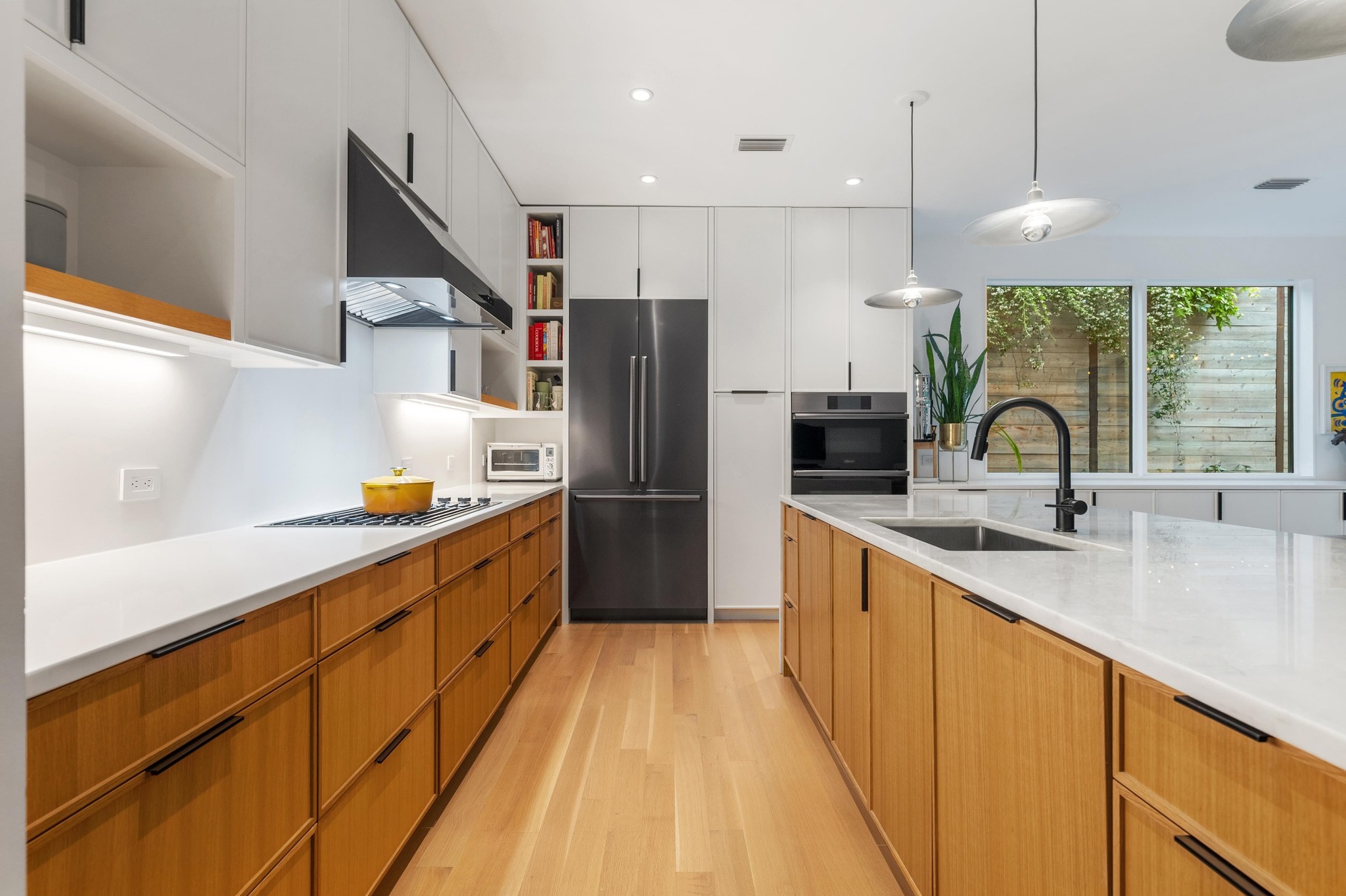 1206 Bickler Road Austin, TX 78704 - Photo 30 of 65 a large kitchen with stainless steel appliances kitchen island a large counter top a sink a stove and a refrigerator