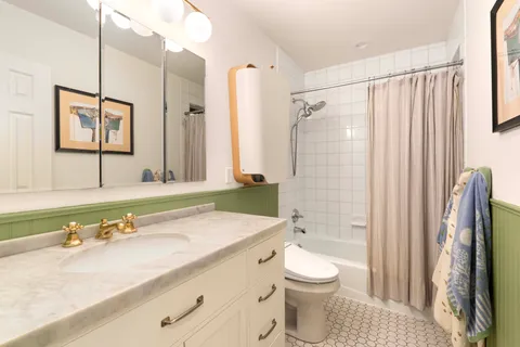 a bathroom with a granite countertop sink toilet and shower