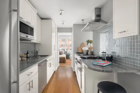 a kitchen with stainless steel appliances a sink stove and cabinets
