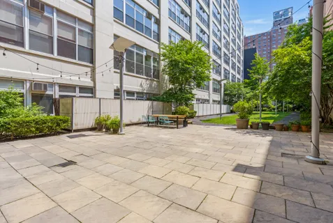 a view of a building with plants and a lawn chair