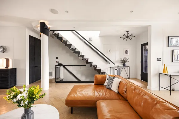a living room with furniture flowers and a chandelier