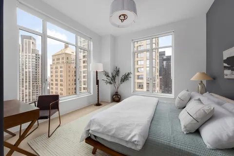 a bedroom with a bed and a large window