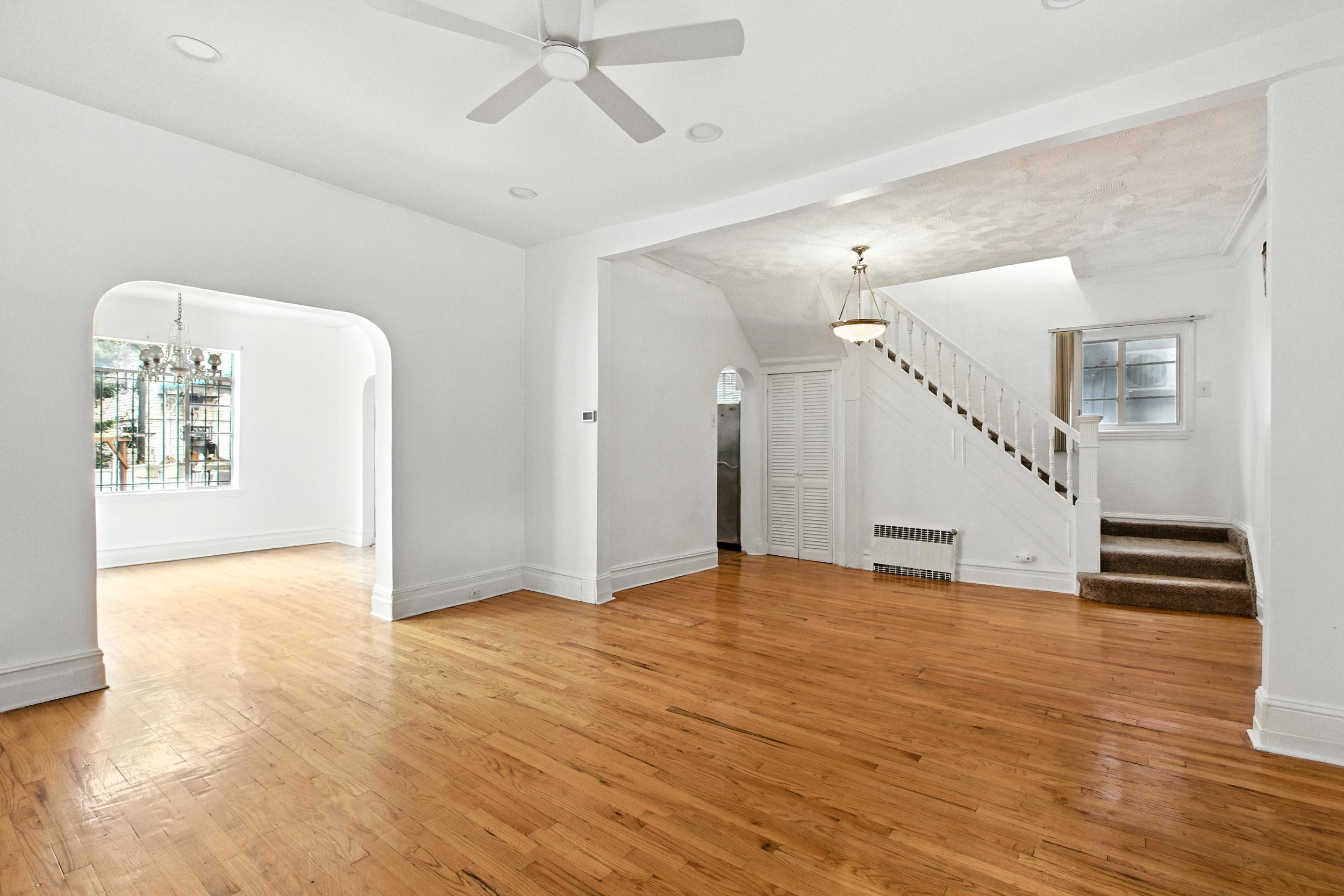 1070 East 13th Street Brooklyn, NY 11230 - Photo 4 of 18 a view of an empty room with wooden floor and a ceiling fan