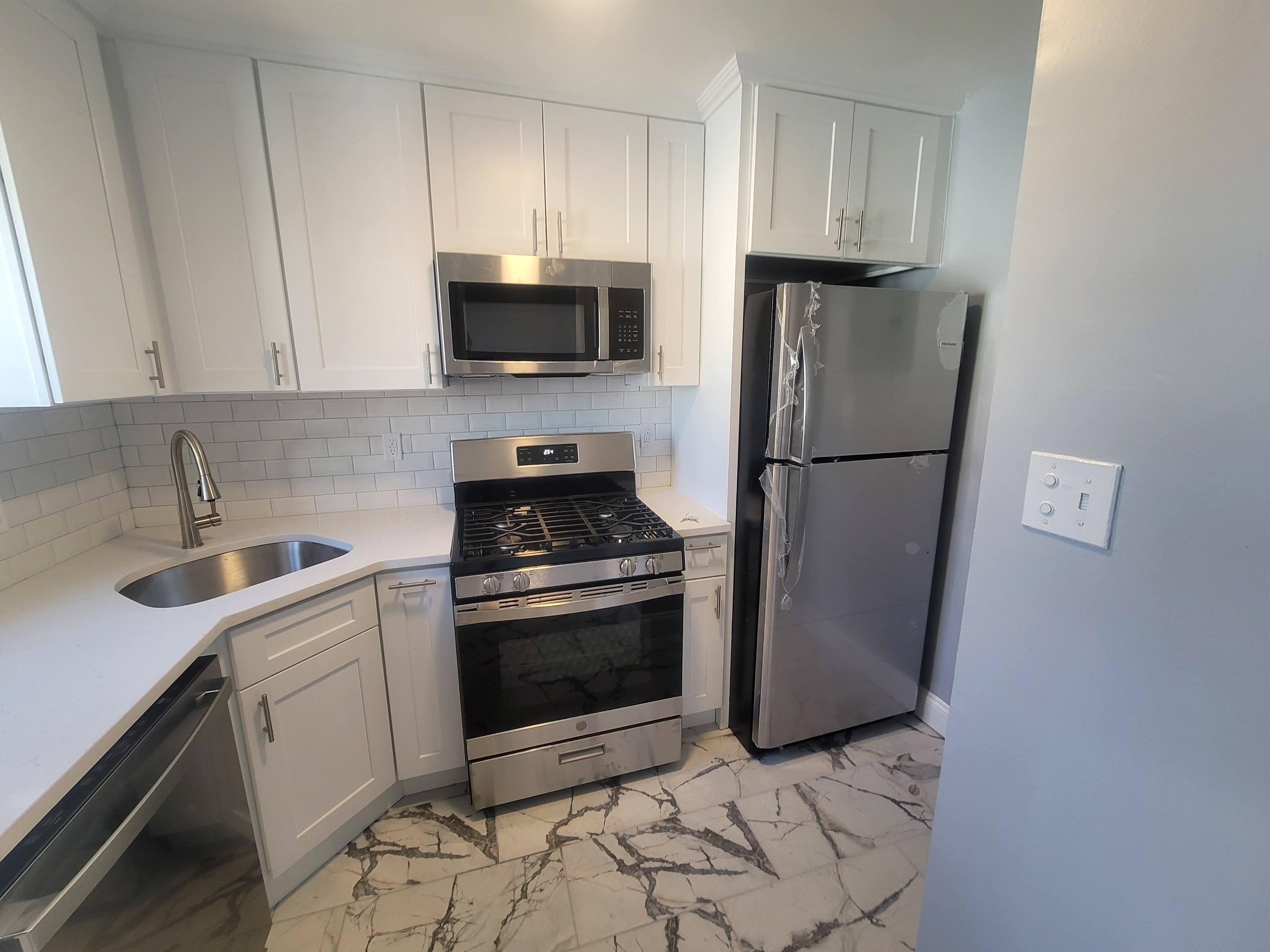 224-24 Manor Road, Unit U Queens, NY 11427 - Photo 5 of 10 a kitchen with a refrigerator sink and cabinets