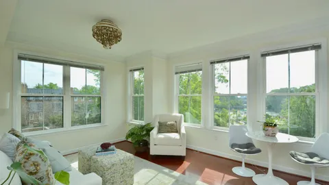 a living room with furniture and floor to ceiling windows