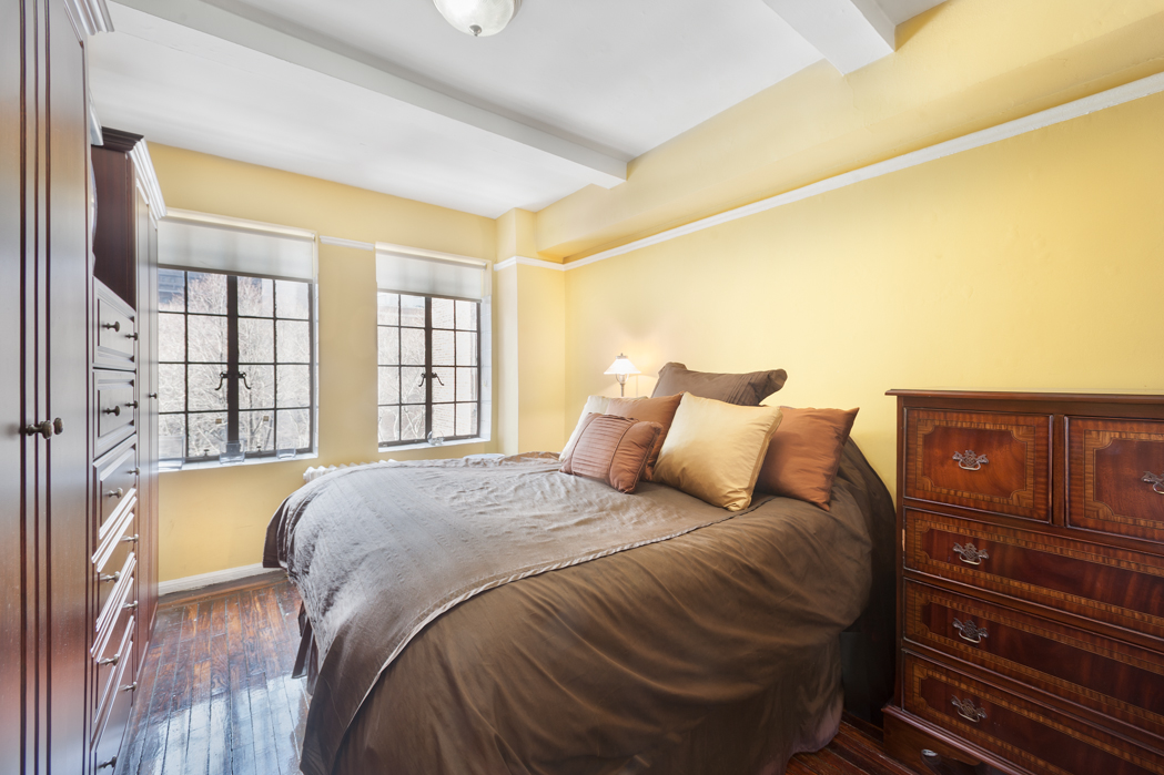 45 Tudor City Place, Unit 615 Manhattan, NY 10017 - Photo 3 of 5 a bed sitting in a bedroom next to a window