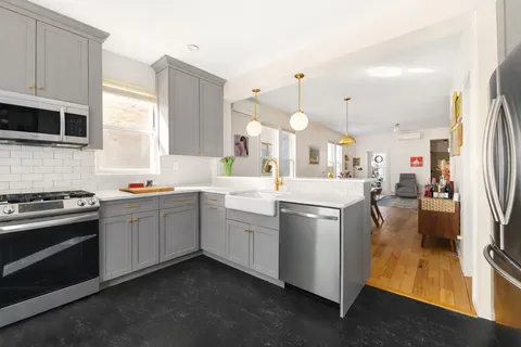 a kitchen with white cabinets and stainless steel appliances