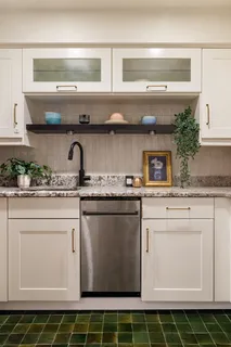 a kitchen with granite countertop a sink a stove and cabinets