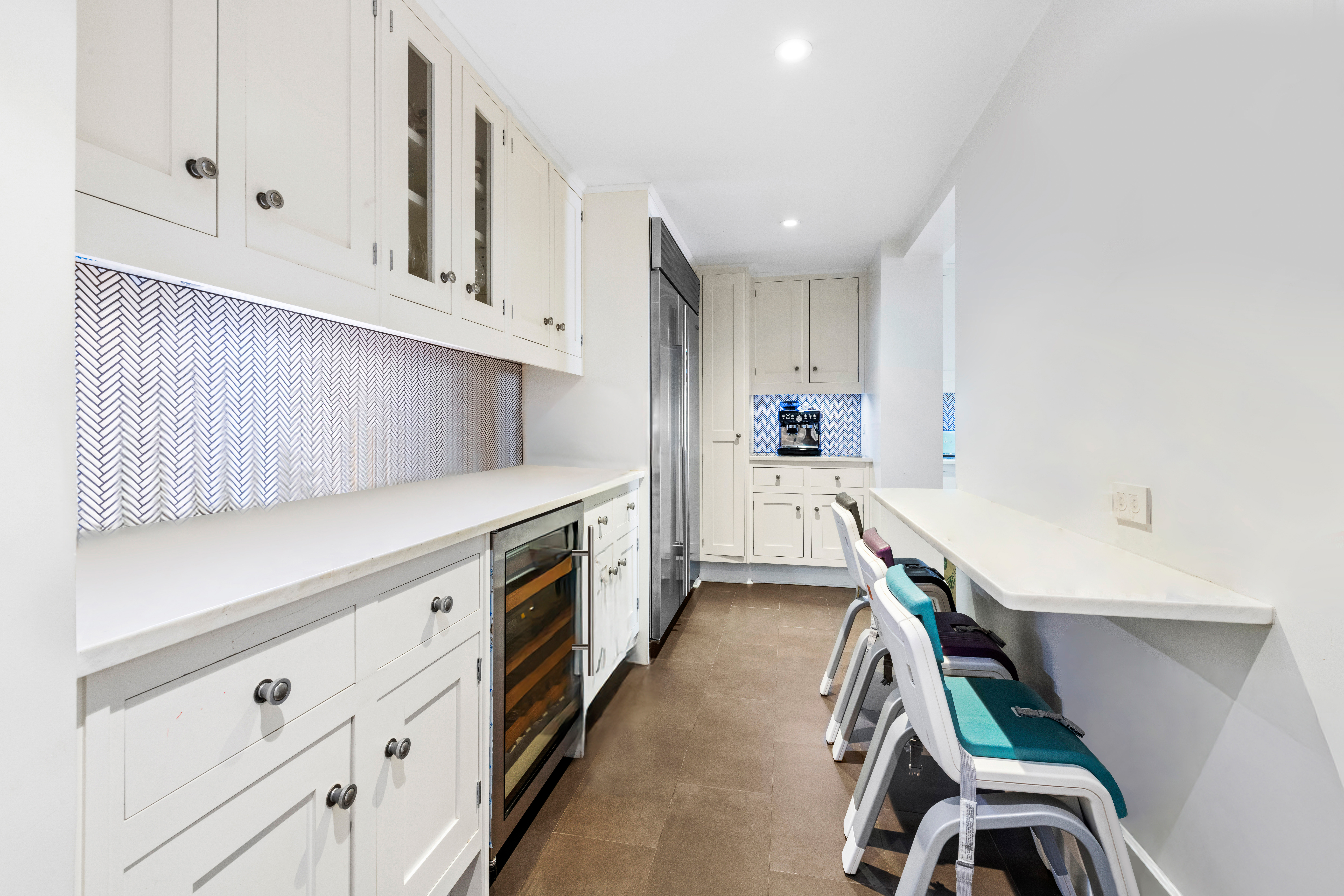 530 Park Avenue, Unit 3F Manhattan, NY 10065 - Photo 6 of 25 a kitchen with wooden cabinets a sink a stove and a window