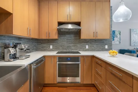 a kitchen with stainless steel appliances granite countertop a sink stove and cabinets