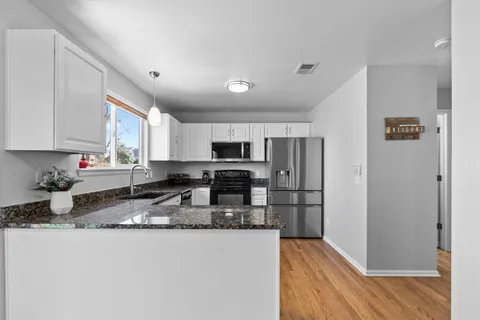 a kitchen with granite countertop a refrigerator sink and stove