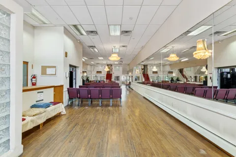 a large living room with stainless steel appliances kitchen view and wooden floor