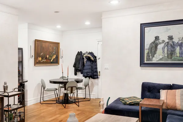 a living room with furniture and a painting on the wall