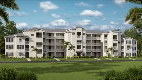 a front view of a building with yard and trees