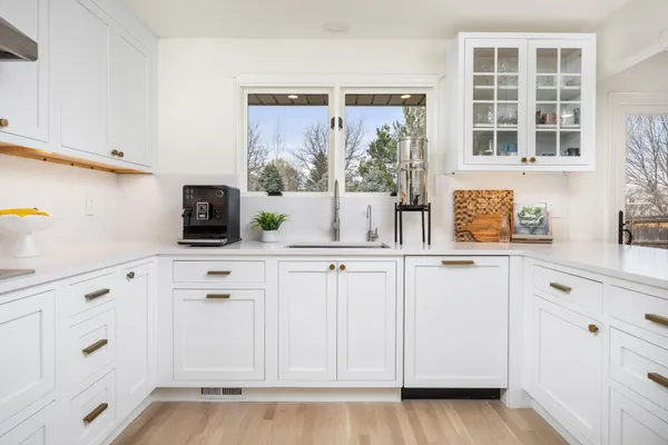 a kitchen with white cabinets and a window