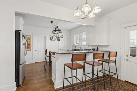 a kitchen with stainless steel appliances a stove a chandelier and a refrigerator