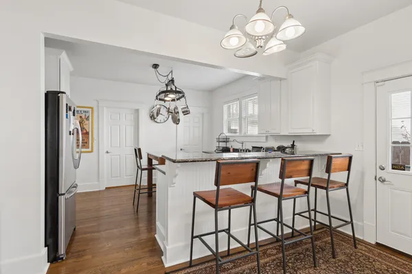 a kitchen with stainless steel appliances a stove a chandelier and a refrigerator