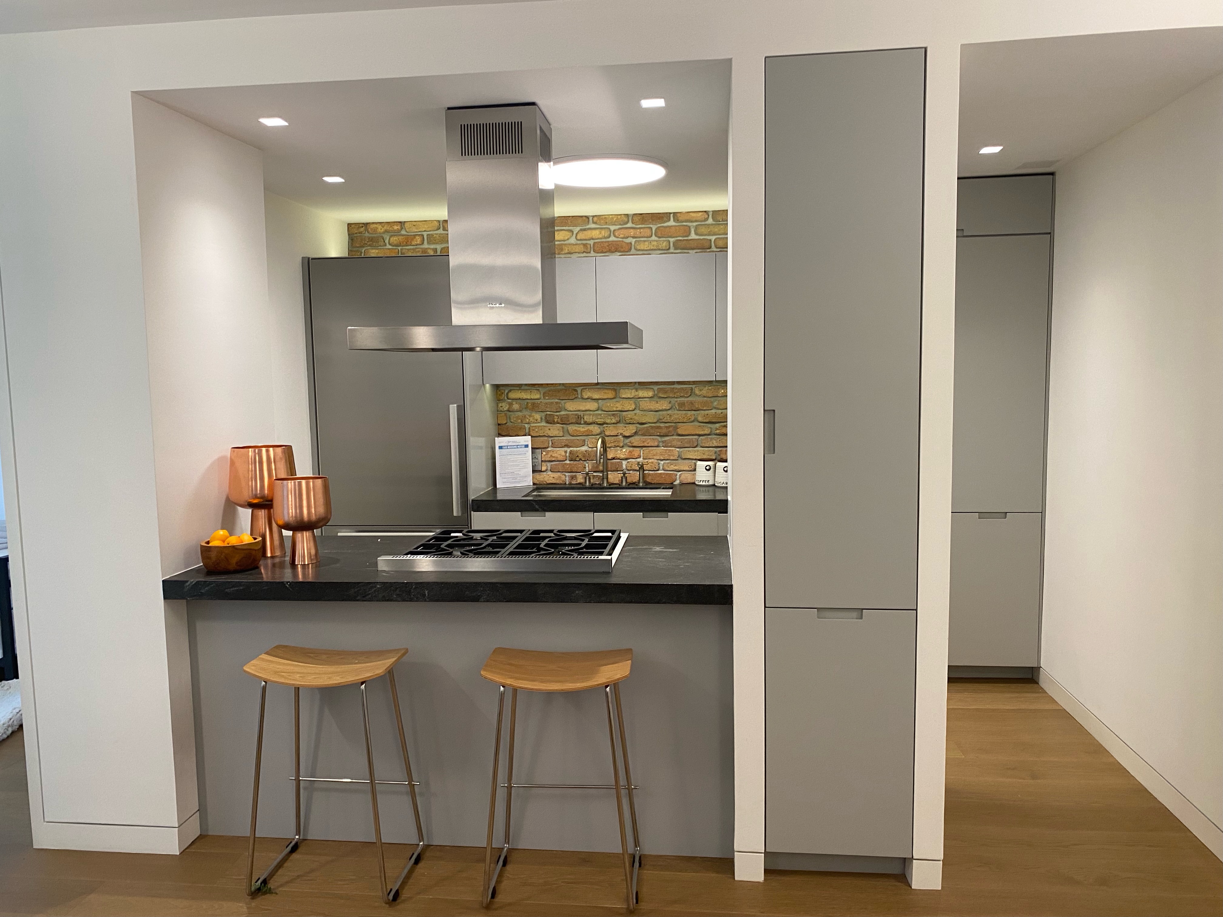 124 East 79th Street, Unit 7D Manhattan, NY 10075 - Photo 5 of 25 a kitchen with kitchen island granite countertop wooden cabinets and counter space