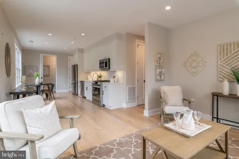 a living room with furniture a flat screen tv and a table