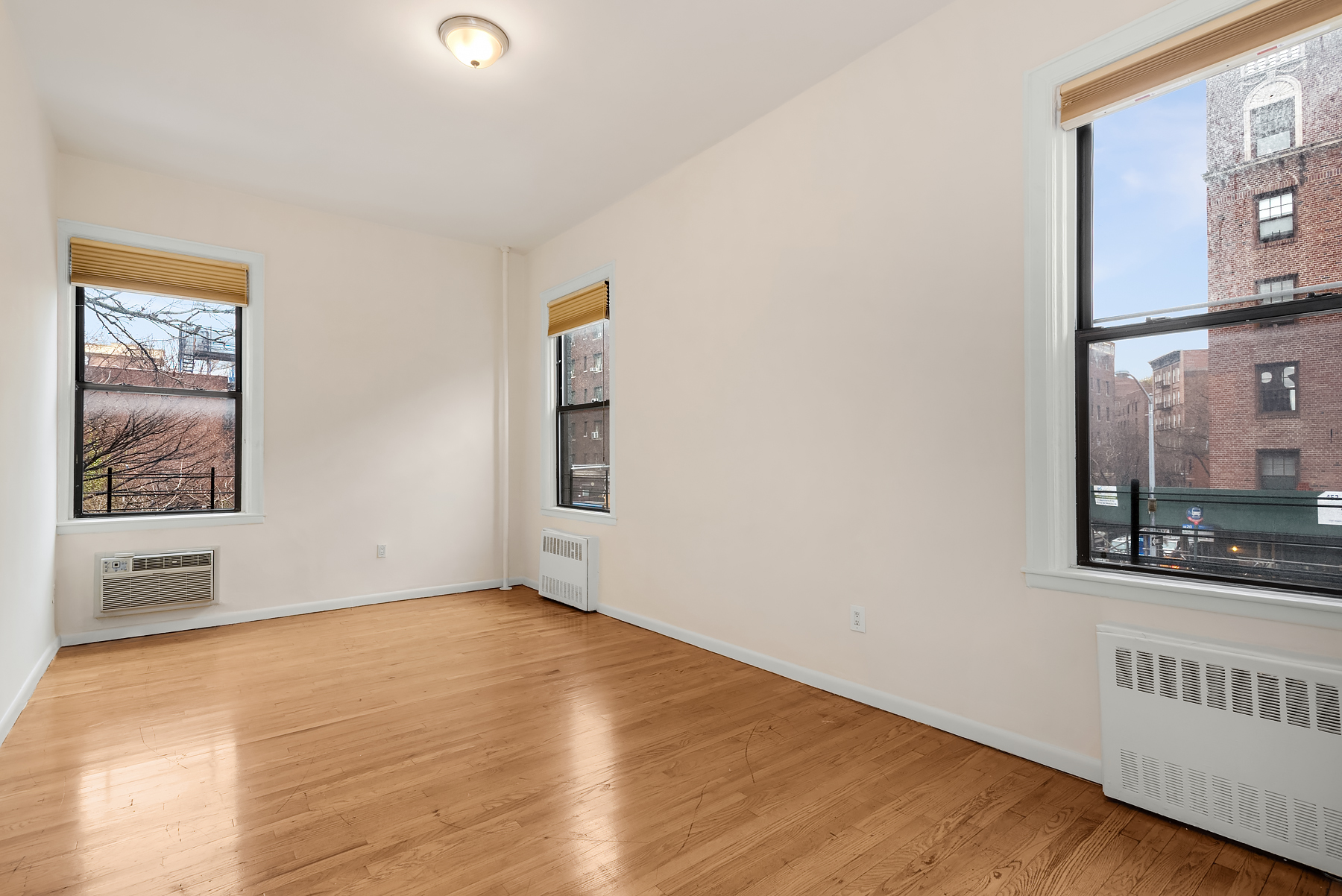 93 Barrow Street, Unit 4 Manhattan, NY 10014 - Photo 2 of 8 a view of an empty room with window and wooden floor