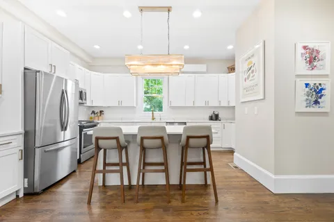 a kitchen with stainless steel appliances granite countertop a refrigerator and a stove top oven