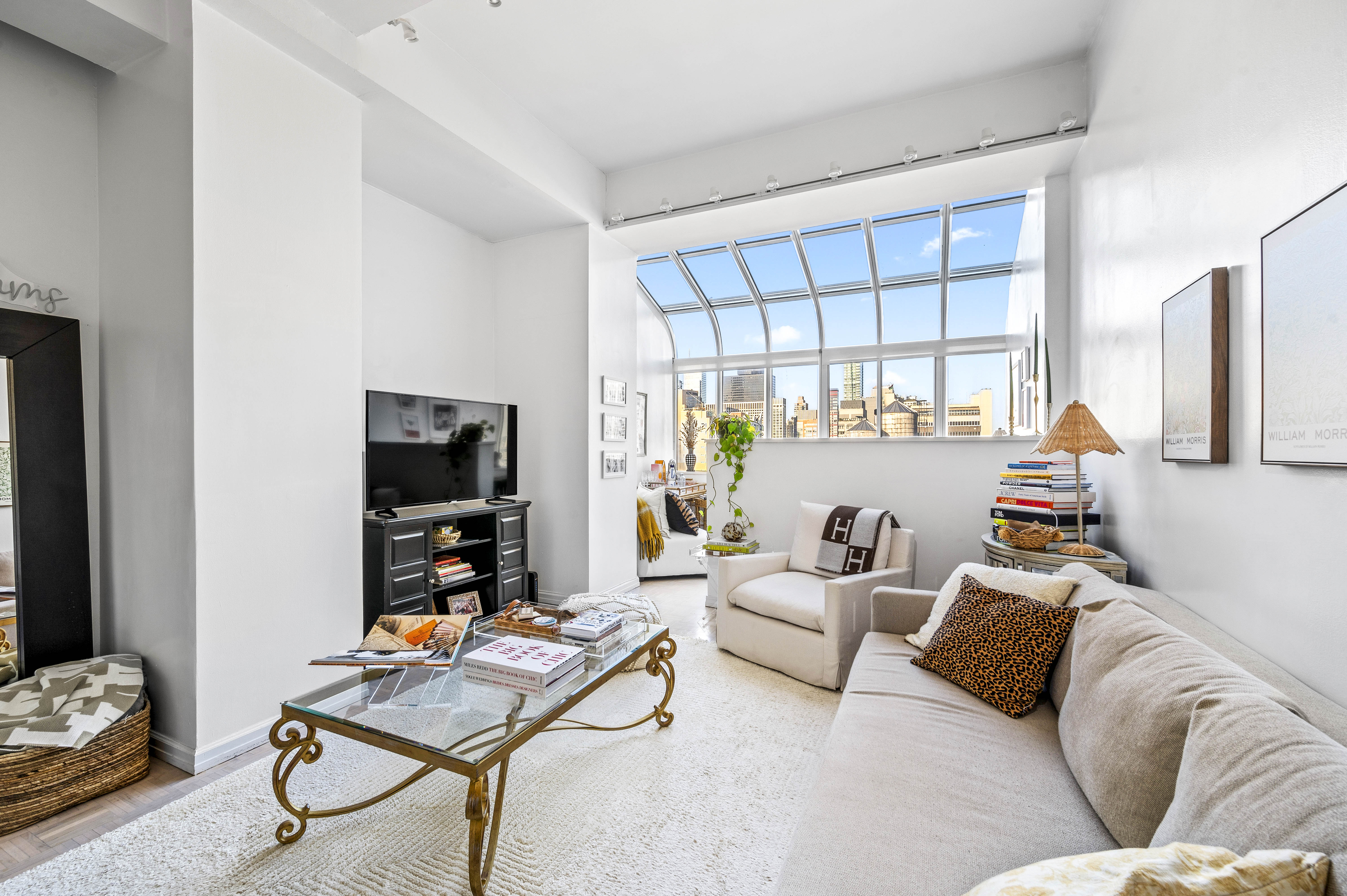 310 East 46th Street, Unit 19F Manhattan, NY 10017 - Photo 1 of 17 a living room with furniture and a flat screen tv
