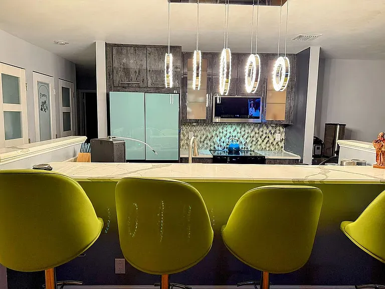 a living room with table chairs and a large window